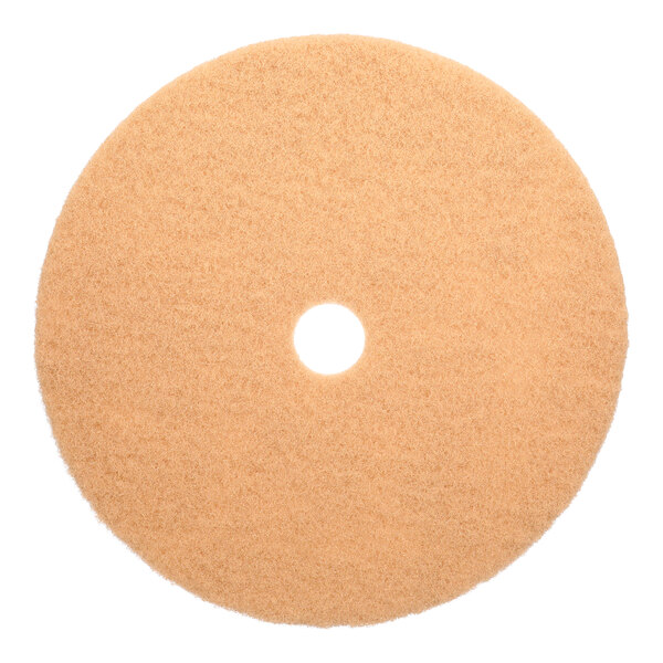 A tan, circular low-frequency floor burnishing pad with a hole in the center.