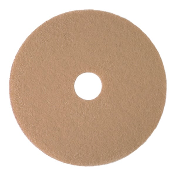 A round tan burnishing floor pad with a central hole, designed for low-frequency floor maintenance.