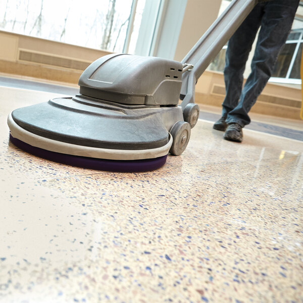A floor burnishing machine being used on a polished surface.
