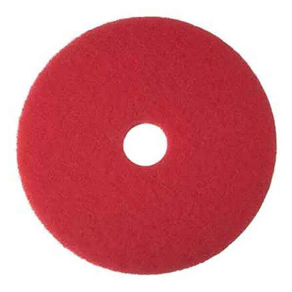 A round red buffing floor pad with a central hole, designed for use with floor cleaning machines.
