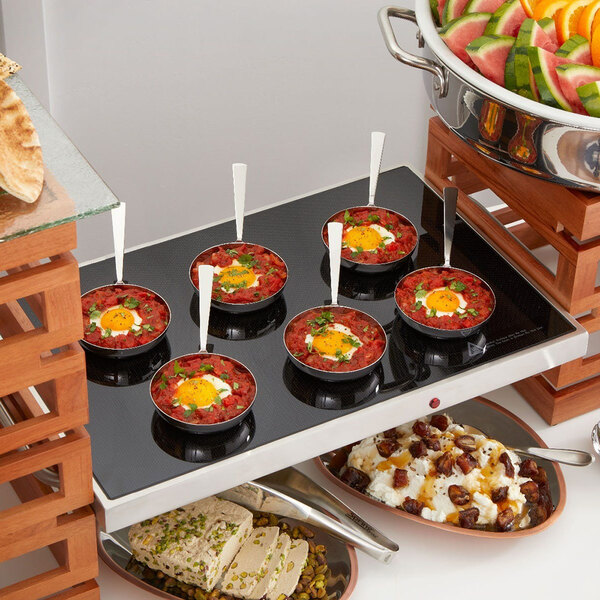 A rectangular stainless steel warming shelf used for keeping food hot, shown here with small dishes placed on top.