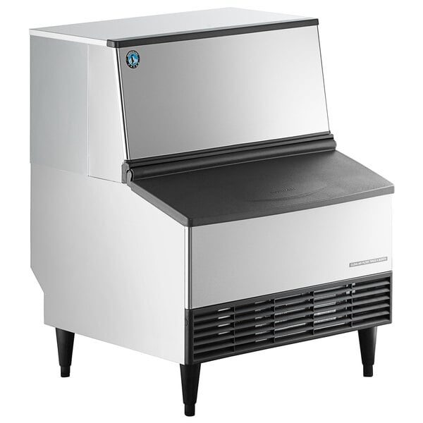 A commercial undercounter ice machine with a built-in storage bin.