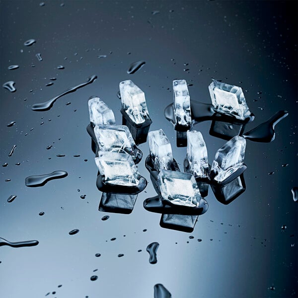A set of clear, small cube ice pieces on a wet, reflective surface.