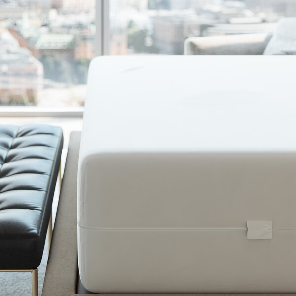 A white waterproof poly knit mattress protector covering a Full XL mattress.