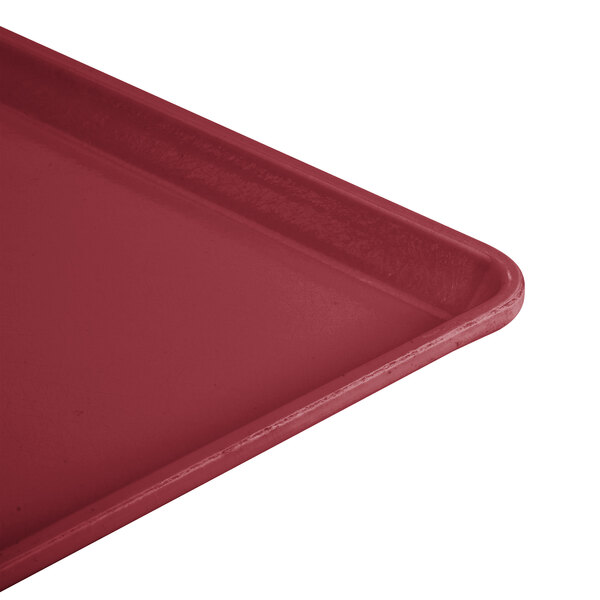 A close-up of a red Cambro dietary tray with a handle.