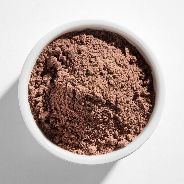 A white bowl filled with a light brown, powdery mix.