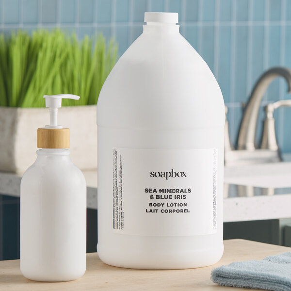 A large gallon container of Soapbox Sea Minerals and Blue Iris body lotion next to a smaller pump bottle.