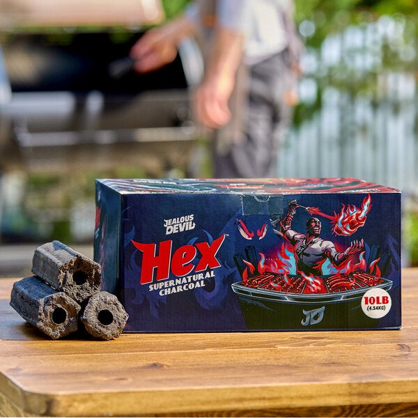 A 10-pound box of Jealous Devil Hex Supernatural Charcoal with several hexagonal charcoal briquettes displayed beside it.