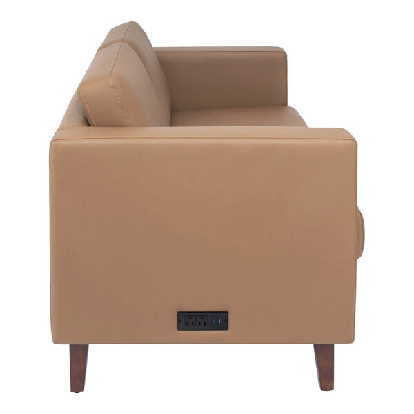 A cognac-colored loveseat with wooden feet and a built-in charging bank on the side.