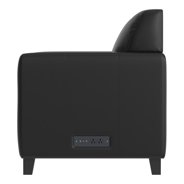 A black leather chair with a built-in charging bank and wooden feet.