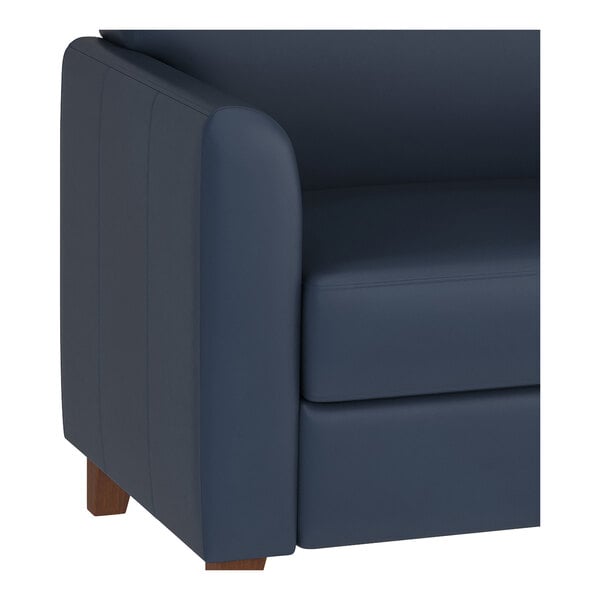A navy blue leather sofa with wooden feet and a modern design.
