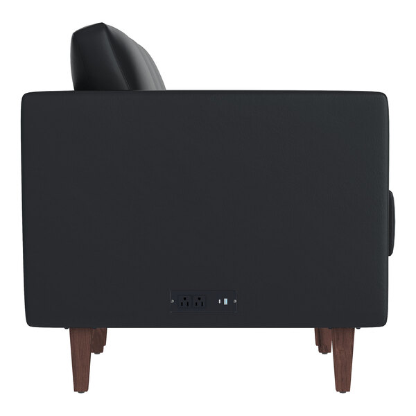 A black leather sofa with wooden feet and built-in charging banks on the side.