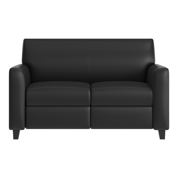 A black leather loveseat with wooden feet and a built-in charging bank.