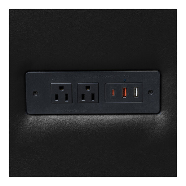 A built-in charging bank with two power outlets and three USB ports on a black leather surface.