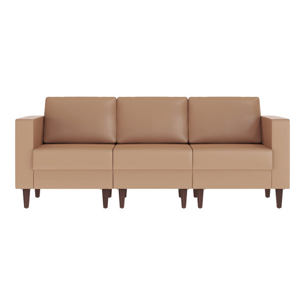 A cognac-colored three-seat sofa with wooden feet and two built-in charging banks.
