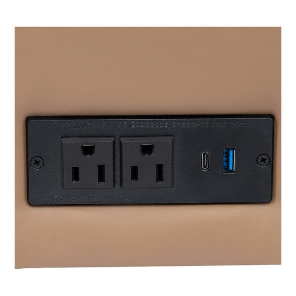 A built-in charging bank with two power outlets, one USB-C port, and one USB-A port on a sofa.