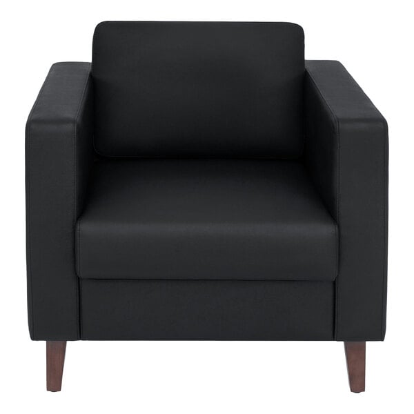 A black leather armchair with wooden legs and a charging bank.