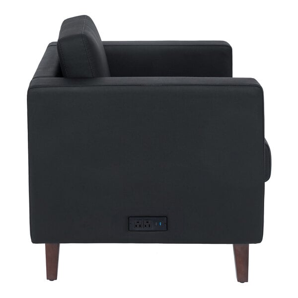 A black leather chair with wooden legs and a built-in charging bank on the side.