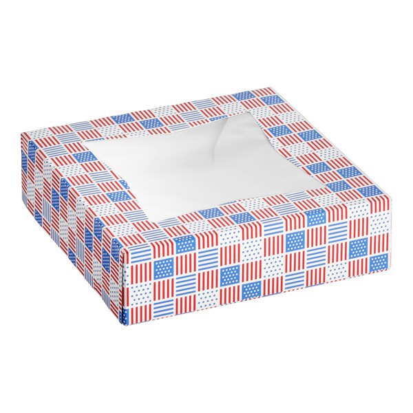 A square bakery box with a patriotic red, white, and blue USA flag print and a clear window on top.