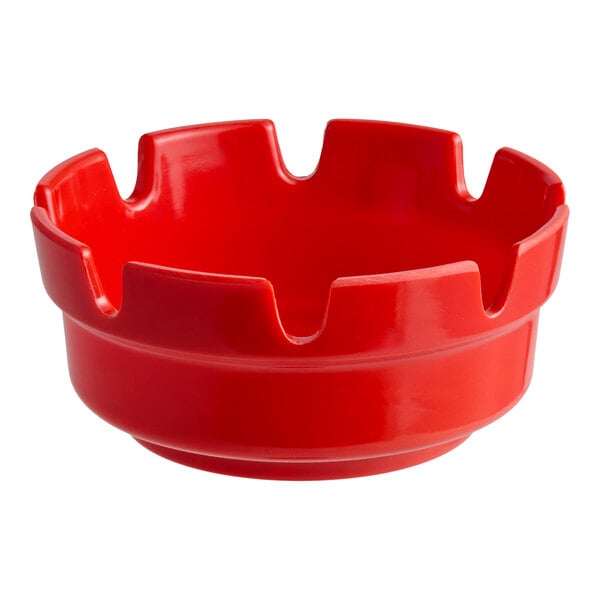 A red plastic ashtray with multiple grooves along the rim.
