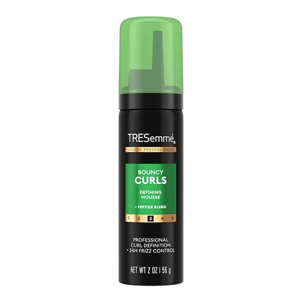 A 2 oz. bottle of TRESemme Flawless Curl Defining Mousse with a green cap.