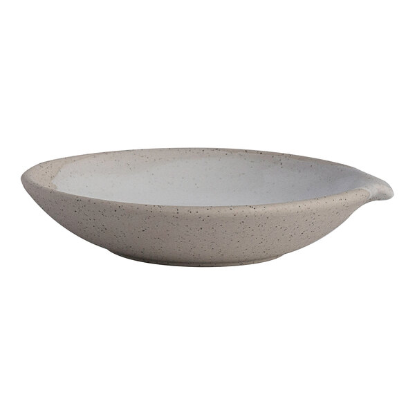 A round white stoneware spouted sauce dish.