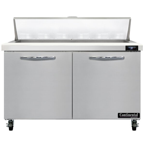 A stainless steel refrigerated sandwich prep table with two doors and a raised ingredient storage area.