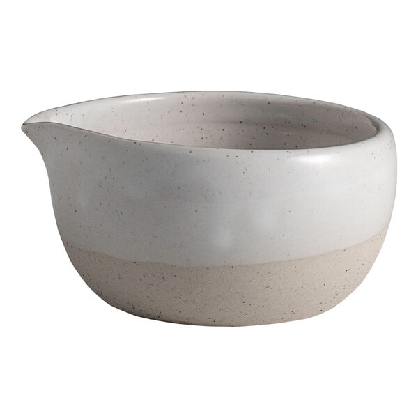 A round white stoneware spouted ramekin with a natural speckled finish.