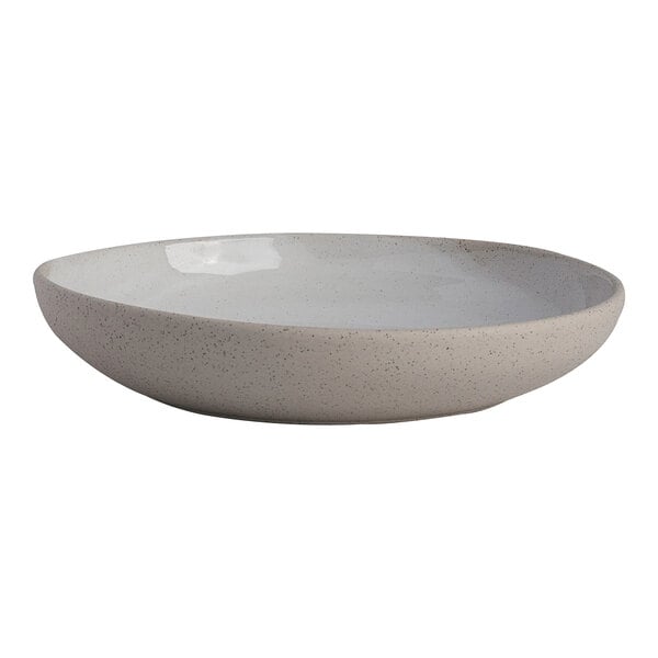 A round white stoneware bowl with a speckled finish.
