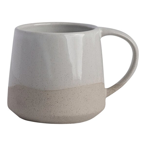 A two-tone white and beige stoneware mug with a handle.