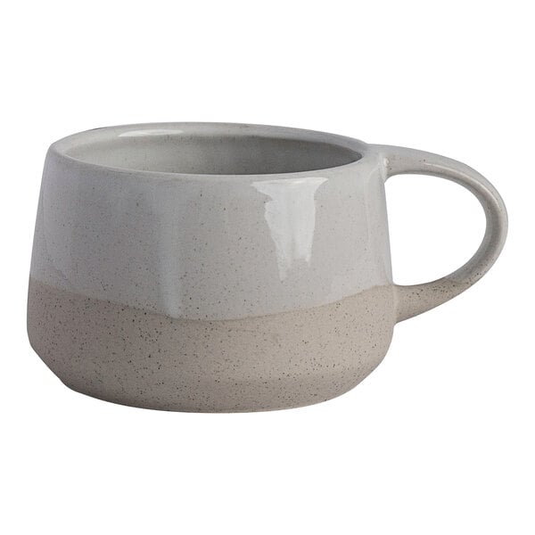 A two-tone white and beige stoneware coffee cup with a handle.