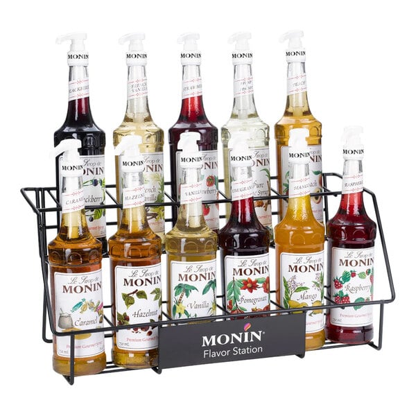 A two-tier wire rack holding eleven bottles of Monin flavored syrups.