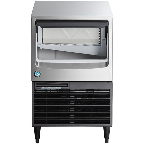 A stainless steel undercounter ice machine with a built-in storage bin.