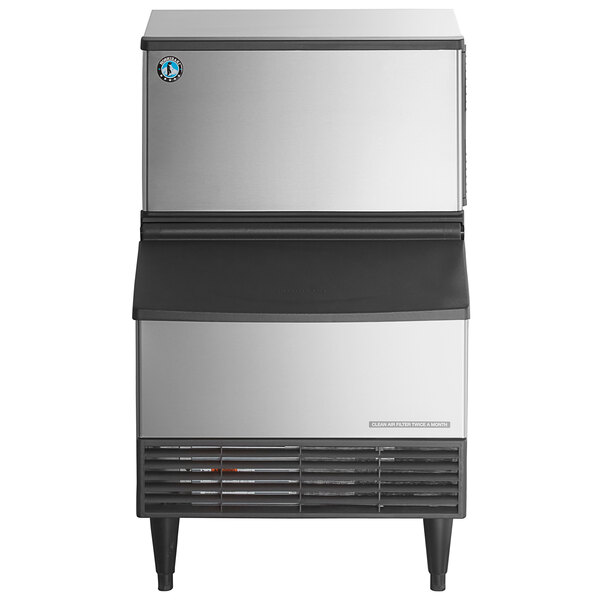 A stainless steel undercounter ice machine with a built-in storage bin.
