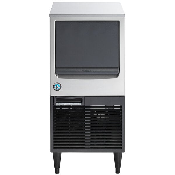 A compact, stainless steel undercounter ice machine with a front-facing black door and built-in storage bin.