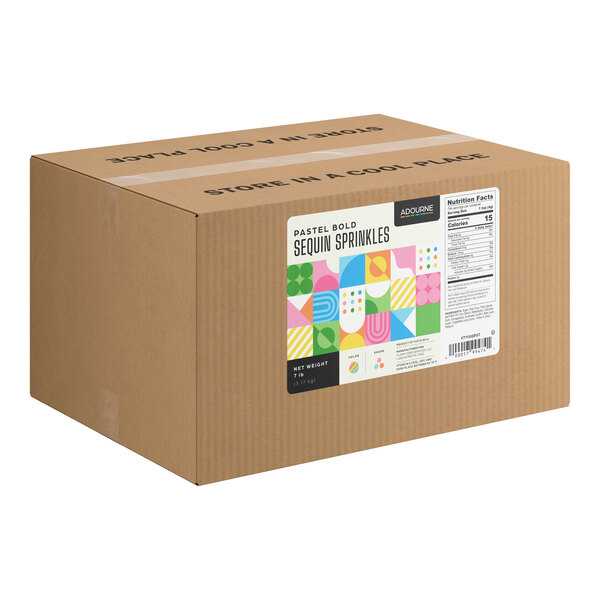 A large brown cardboard box with a colorful label indicating it contains pastel bold sequin sprinkles, along with nutrition facts and storage instructions.