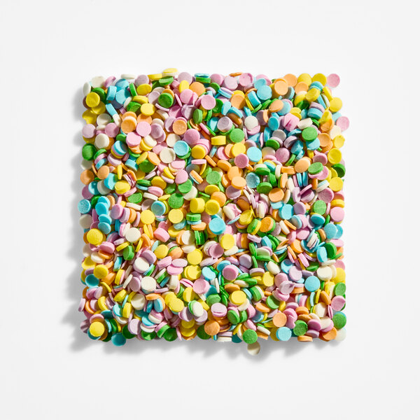 A square pile of small, round, pastel-colored confetti-like sprinkles arranged on a white background.