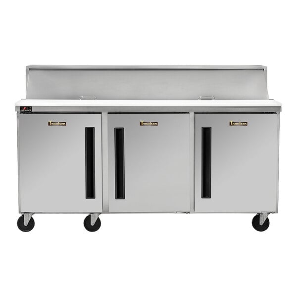 A stainless steel three-door refrigerated sandwich prep table on wheels.