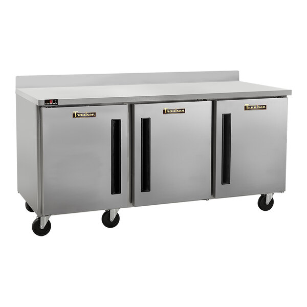 A stainless steel three-door worktop freezer with a 4-inch backsplash and casters.