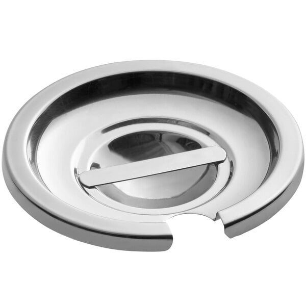 A round, notched stainless steel vegetable inset cover with a central handle.
