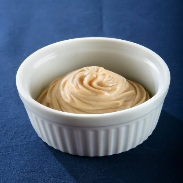 A white ramekin filled with a swirl of light brown butter sauce base.
