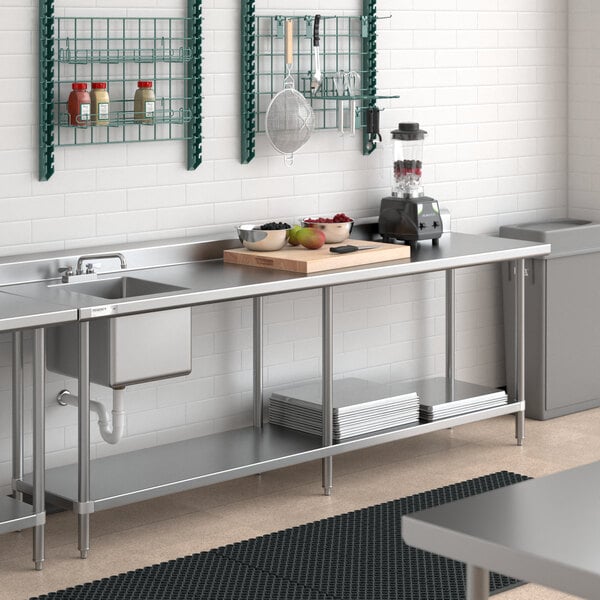 A stainless steel work table with an integrated sink on the left side and an undershelf for storage.