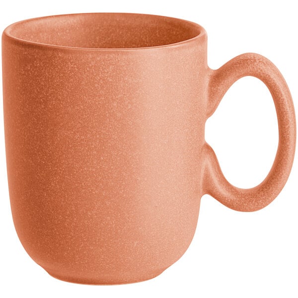 A matte terra cotta-colored porcelain cup with a rounded handle.