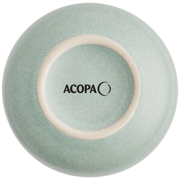 The image shows the bottom view of a small, round, matte-finish porcelain dish in a light blue-green color with the brand name 'ACOPA' printed on the base.