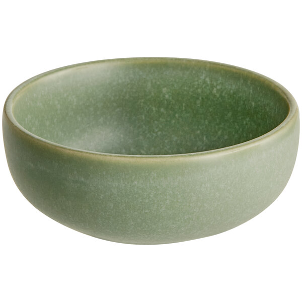 A small, round bowl with a matte sage green finish.