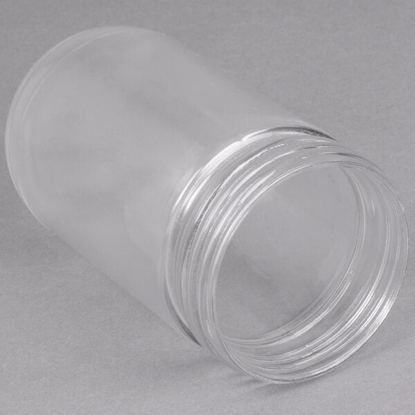 A clear plastic jar with a lid on a white surface.
