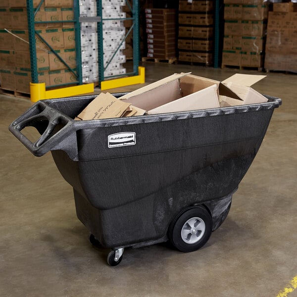 A large black Rubbermaid tilt truck full of cardboard boxes.