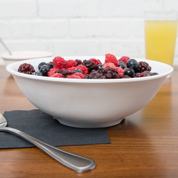 A white bowl filled with berries on a table.