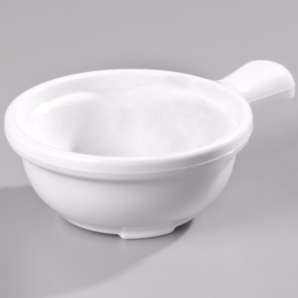 A close up of a white Carlisle polycarbonate soup bowl with a handle.