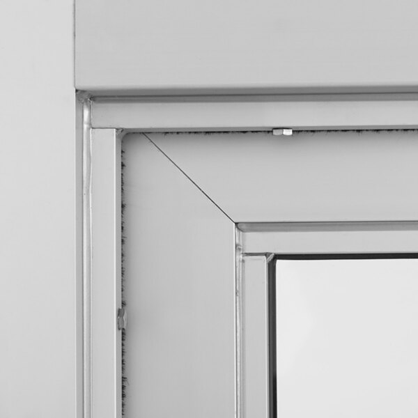 A close-up view of a metal-framed automotive drive-thru window with glass panel.